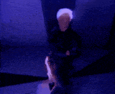 a person with white hair is standing in a dark room with a blue light behind them