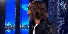 a man with long hair and a beard is standing in front of a star