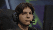a man wearing headphones and a microphone looks to the side