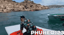 a man is sitting on a raft in the middle of the ocean .