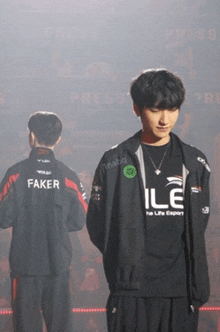 a man in a faker jacket stands in front of a crowd