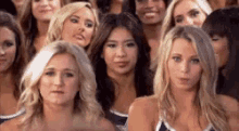 a group of cheerleaders are posing for a picture in a crowd .