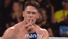 a wrestler holds his finger to his mouth with the word manny above him