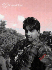 a man in a plaid shirt is standing in front of a pink background with sharechat written on it