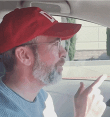 a man with a beard wearing a red hat with a letter d on it
