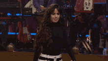 a woman in a black turtleneck is standing on a stage in front of a band