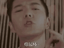 a close up of a man 's face with his eyes closed and a foreign language on his face .