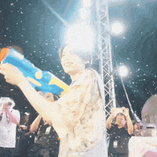 a person holding a water gun with the word aa on the bottom right