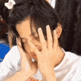 a person covering their face with their hands while wearing a shirt that says nike