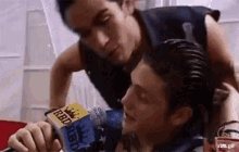two men are sitting next to each other and one of them is holding a microphone in his hand .