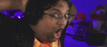 a man wearing glasses and headphones is making a funny face while playing a video game .