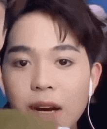 a close up of a young man 's face with earphones on .