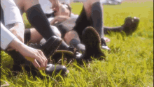 a group of people laying in the grass with their feet in the grass