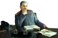 a man with a mustache is sitting at a desk with a book