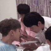 a group of young men are sitting around a table eating food from plates .