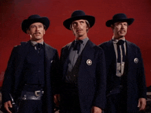 three men standing next to each other wearing sheriff badges on their jackets