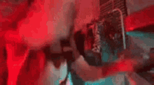 a person is standing in a dark room with red lights behind them .