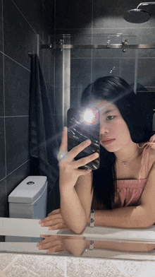 a woman is taking a picture of herself in the mirror