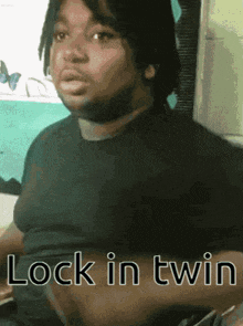 a man in a black shirt with the words lock in twin on his chest