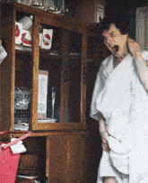 a man in a white towel screams in front of a cabinet with a pepsi sign on it