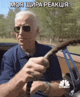 a man wearing sunglasses is driving a car with cnbc written on the bottom