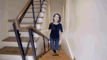 a woman walking down a set of stairs with a black shirt on