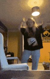 a woman wearing headphones is dancing in front of a sign that says keep out