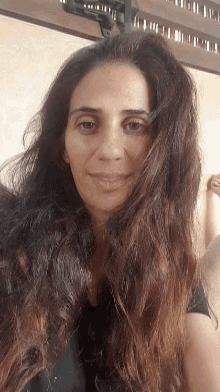 a woman with very long hair is smiling and looking at the camera