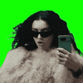 a woman wearing sunglasses and a fur coat is taking a selfie
