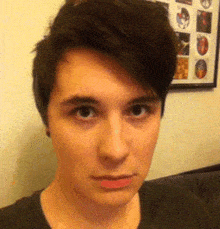 a close up of a person 's face with a framed picture behind them