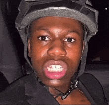 a close up of a person wearing a helmet with their mouth open