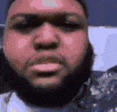 a close up of a man 's face with a beard .