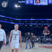 a man in a lynx jersey walks on the court