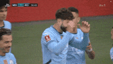 a group of soccer players are celebrating a goal during a game sponsored by itv sport