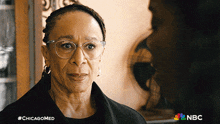 a woman wearing glasses talks to another woman with #chicagomed written on the bottom right
