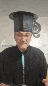 a man wearing a graduation cap and gown has tiktok written on the bottom