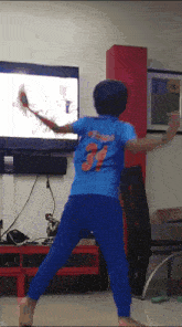 a boy in a blue shirt with the number 3 on the back is playing a video game