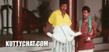 two men standing next to each other with the website kuttychat.com in the lower right corner