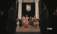 a group of people are dancing in front of a door that says tna on the bottom