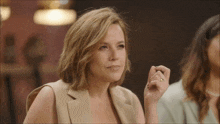 a woman with a gold ring on her finger looks at the camera
