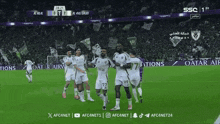 soccer players on a field with ads for qatar air behind them