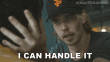 a man wearing a san francisco giants hat says " i can handle it "