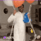 a man in a white robe is holding three balloons