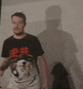 a man is wearing a black shirt with chinese characters on it