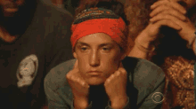 a woman wearing a red headband is sitting in a crowd of people