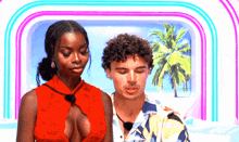 a man and a woman are standing next to each other in front of a beach