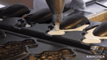 a person is pouring batter into a mold that says made in animotica on the bottom