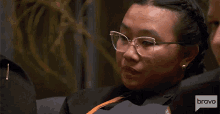 a woman wearing glasses and a bravo logo