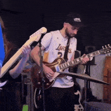 a man wearing a lakers jersey plays a guitar