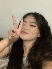 a woman giving a peace sign with her finger
